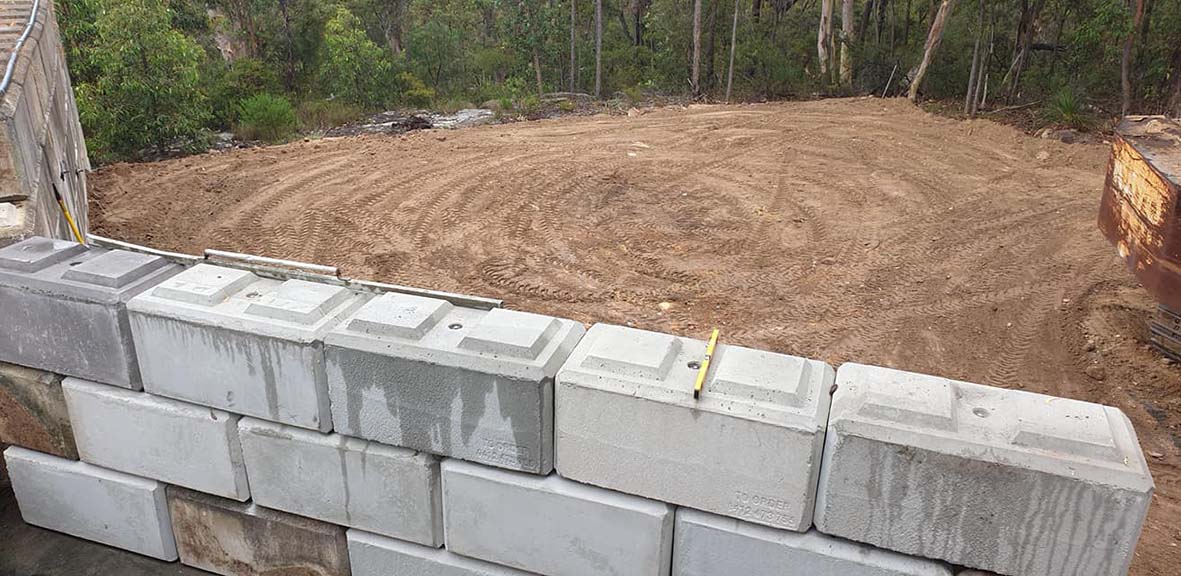 Clearing for water tank, Interlocking mortarless blocks, best concrete block curved retaining wall